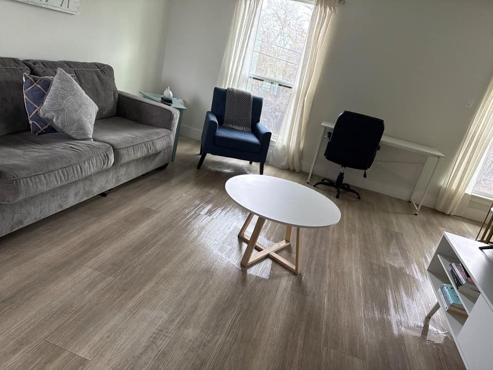 Clean living room with a sofa, armchair and coffee table on wiped wood floors